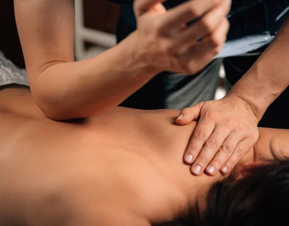 Masaža leđa pritiskom podlaktice i dlana terapeuta.