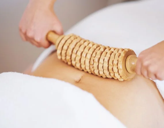 A wooden roller used to massage a leg.